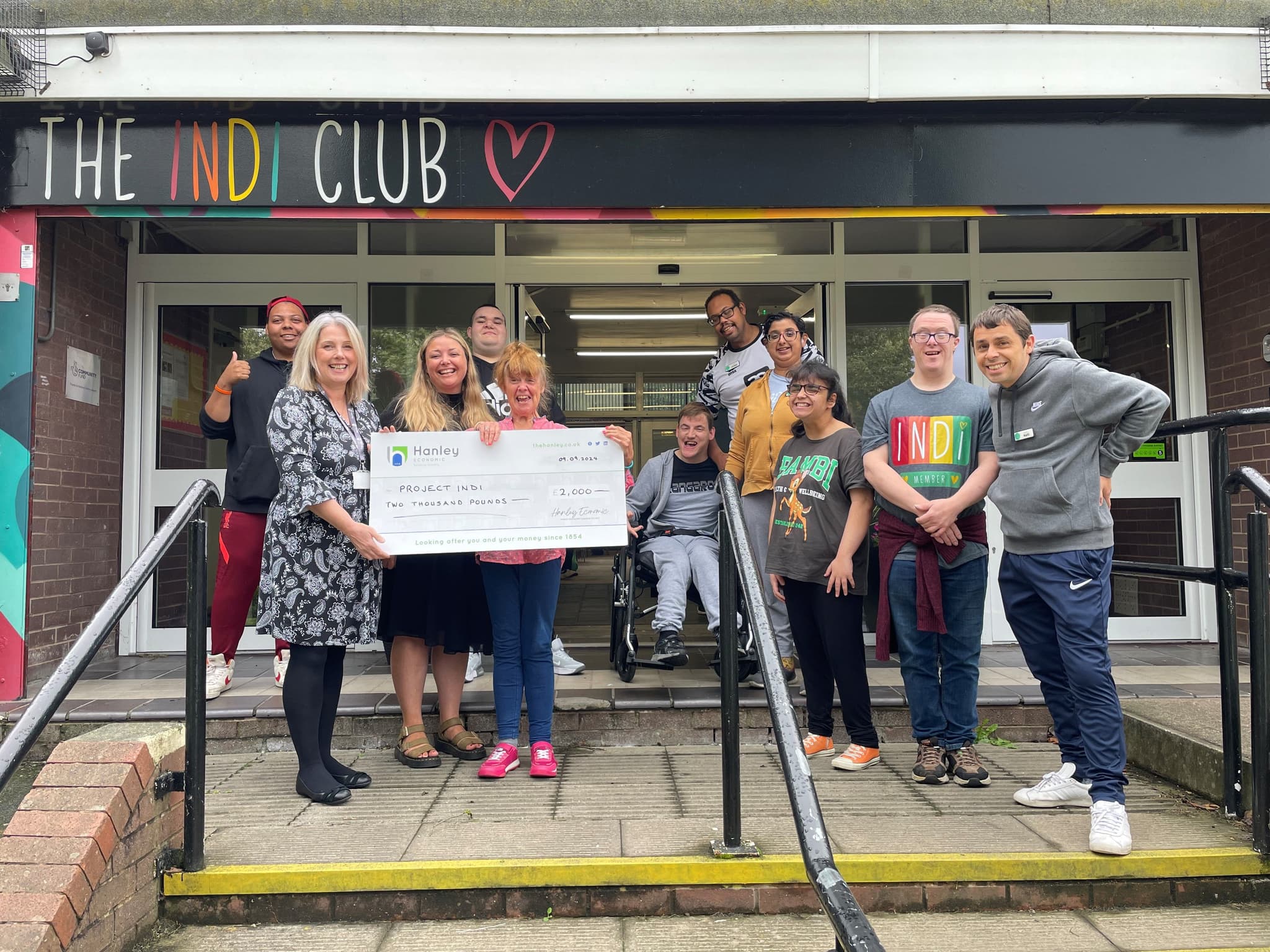 Community Engagement officer providing £2,000 donation to the Indi Club Charity