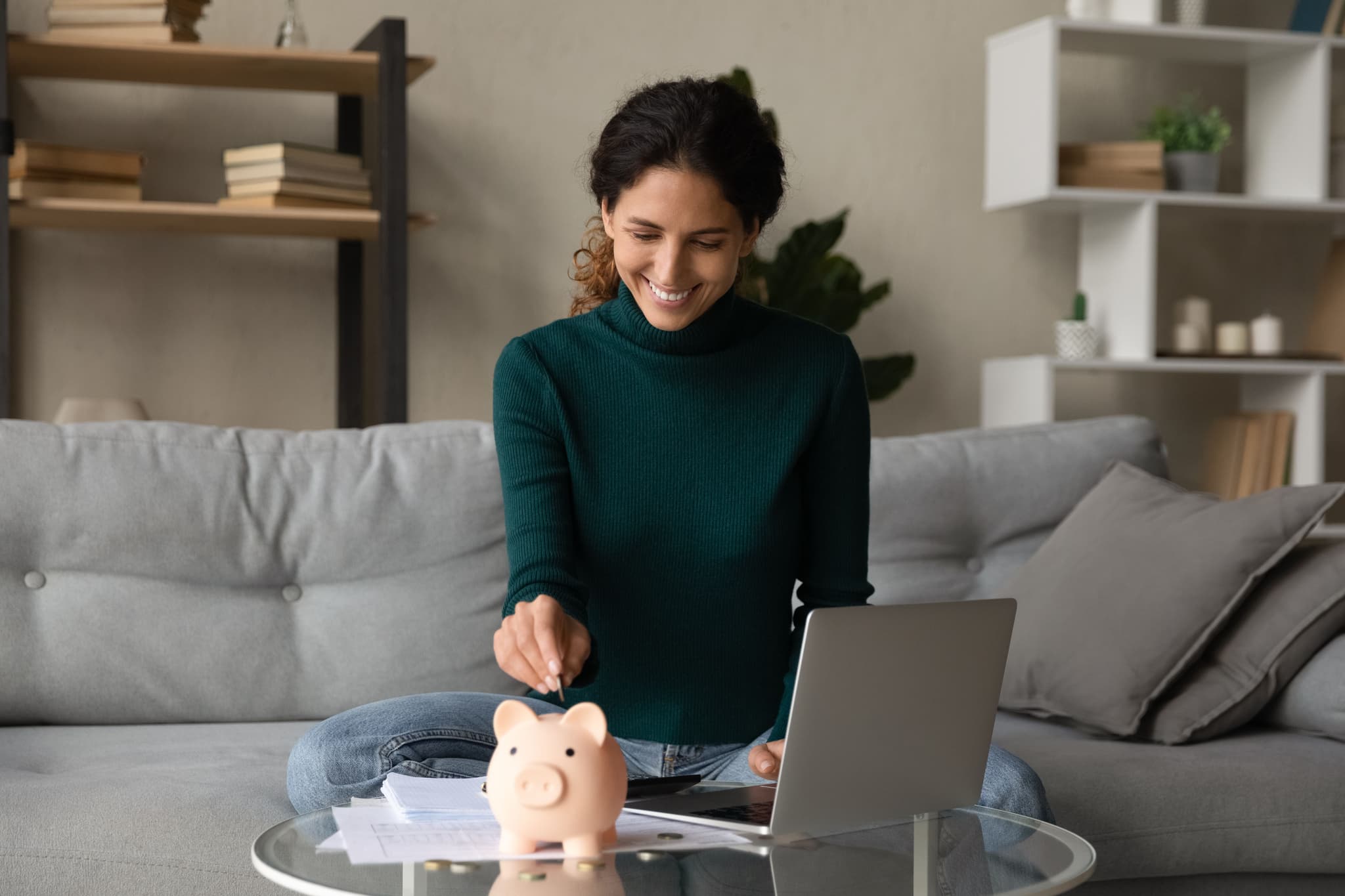 Image of woman putting coins in piggy bank