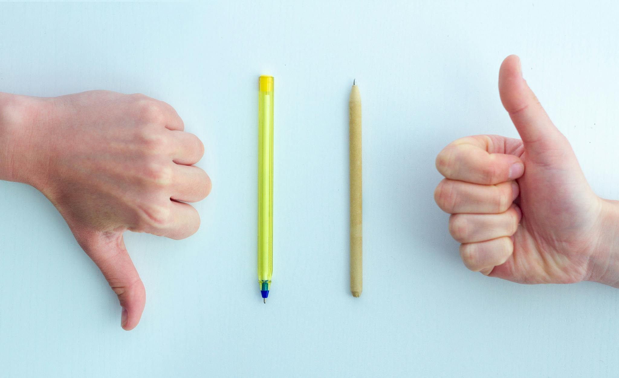 Image of thumbs down for plastic pens and thumbs up for bamboo pens